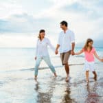 Family-Walking-In-The-Ocean-Holding-Hands