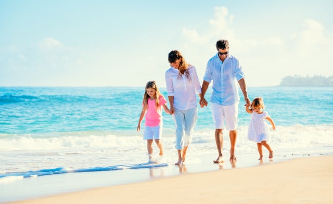 Family-Walking-On-Beach-Holding-Hands
